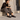 Mocassins artisanaux Billi bi en cuir noir portés par une femme assise sur des marches en pierre