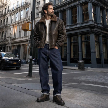 Homme portant veste pilote cuir et chaussure oxford Courrier cg sur rue Manhattan