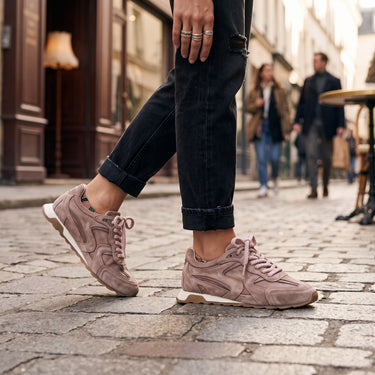 Baskets Ash Kasar rose en daim stone washed portées avec un jean noir dans une rue pavée