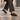 Mocassins artisanaux Billi bi noirs en cuir athène portés avec un pantalon gris sur des pavés, moodeshop