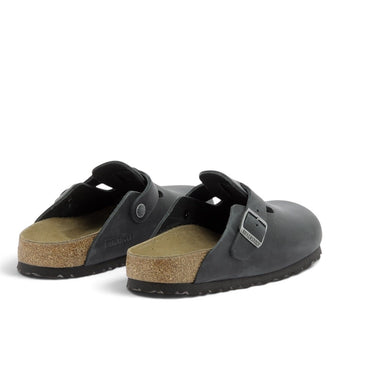 Sabots Birkenstock Boston en cuir huilé noir avec semelle en liège et boucle réglable, disponibles chez moodeshop