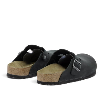 Sabots Birkenstock Boston en cuir huilé noir avec semelle en liège, disponibles chez moodeshop